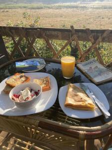 苏丹巴特利Lotus Jewel Forest Camping的一张桌子,上面放着一盘食物和一碗烤面包