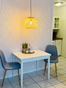 费马恩Kajüthus Apartment 4的餐桌、两把椅子和灯具