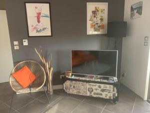 卡布勒通APPARTEMENT PLAGE EN RESIDENCE ENTIER 2 CHAMBRES的客厅配有电视和椅子