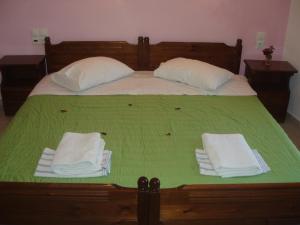 梅加利阿莫斯海伦公寓的一张带绿色床单和白色毛巾的床