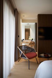 雅典Dusit Suites Athens的配有床、椅子和镜子的房间