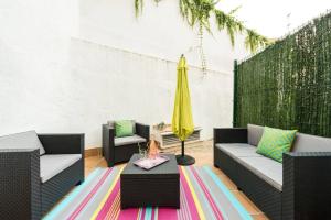 马德里Apartamento con jardin privado y portero (A)的天井配有两把椅子、一张桌子和一把黄色雨伞