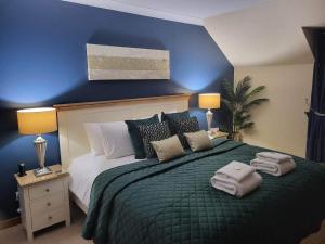 因弗内斯艾瓦伦酒店的一间卧室设有一张蓝色墙壁的大床