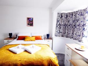 剑桥Modern, well located en-suite rooms with parking and all facilities的一间卧室配有黄色的床和两个枕头