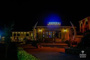 KyabinungaIgongo Country Hotel & Cultural Centre的一座晚上在上面标有蓝色标志的建筑