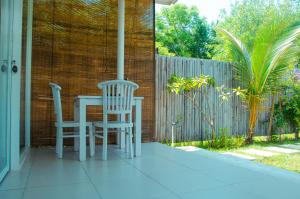 吉利美诺Villa Samalas Resort and Restaurant的门廊上配有桌子和两把椅子