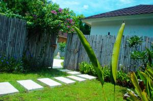 吉利美诺Villa Samalas Resort and Restaurant的后院设有木栅栏和花园