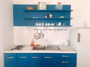 圣内德尔贾Apartmani Diego的厨房配有蓝色橱柜和白色冰箱
