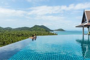塔林甘海滩InterContinental Koh Samui Resort, an IHG Hotel的坐在度假村无边游泳池中的一对夫妇
