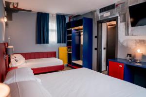 佩斯基耶拉德加达K MODERN HOTEL的一间带两张床和电视的小卧室