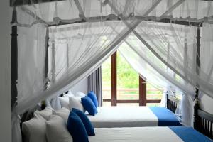 马特勒Beach Inns Holiday Resort - Celeste的一间卧室配有两张带蓝白色枕头的床