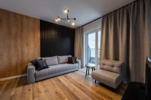 科沃布热格Horyzont Apartamenty -Bałtycka2 - SAUNA & FITNESS - ŚNIADANIA的客厅配有沙发和椅子