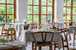锡尔克堡Gl Skovridergaard的一间设有白色桌椅和窗户的用餐室