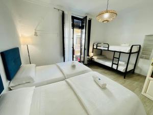 格拉纳达Pension Venecia Gomerez的白色的客房设有两张床和一张双层床。