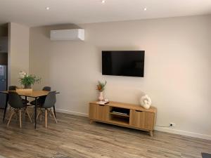 谢珀顿Shepparton Lakeside Serviced Apartment的客厅配有桌子和墙上的电视