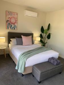 谢珀顿Shepparton Lakeside Serviced Apartment的一间卧室配有一张大床和植物