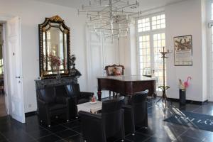 弗尔内Amaryllis Hotel Veurne的一间设有钢琴、椅子和镜子的客房