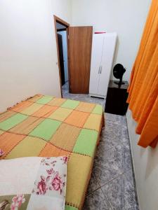 皮乌马Apartamento de 2 quartos的一间卧室配有一张带彩色毯子的床