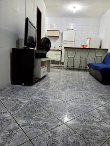 皮乌马Apartamento de 2 quartos的客厅铺有瓷砖地板,配有电视和沙发