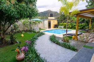 哈拉瓦科阿Villa Rosalía Jarabacoa con Piscina Climatizada的一个带游泳池和房子的后院