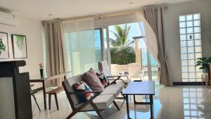Ban Phlong TakheW Sea beach Rayong的客厅配有沙发和桌子