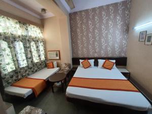 斋浦尔Kailash Hotel的酒店客房设有两张床和窗户。