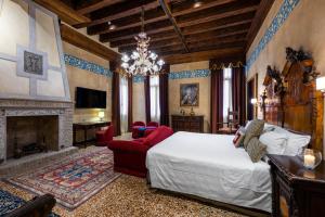 威尼斯帕拉佐普瑞里酒店的一间卧室设有一张大床和一个壁炉