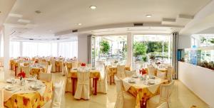 科林比亚克林比亚骄阳酒店的宴会厅,配有桌椅