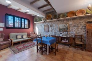 AlbentosaCASA RURAL VICENTA 1750的客厅配有桌椅和石墙