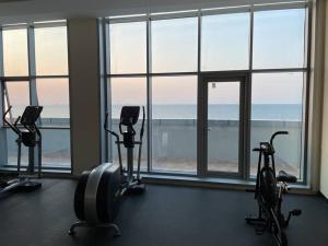 阿吉曼Luxurious Sea View - Beach Front的窗户前的健身房,有3辆运动自行车