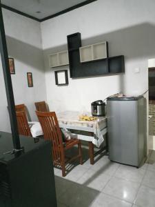 岩望pandya Bromo的厨房配有冰箱和桌椅