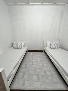 丹那拉打lily maison的白色墙壁客房的两张床