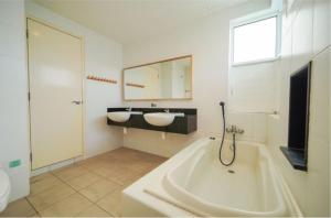 乔治市Nautilus Bay Home Inn的浴室配有两个盥洗盆和浴缸。