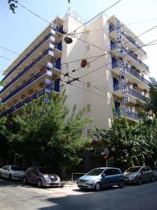 雅典卡斯姆斯酒店的前面有汽车停放的建筑