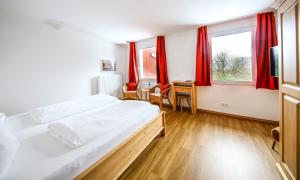 欣特察尔滕Hotel Lafette的一间卧室配有大床和红色窗帘