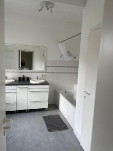 SorinnesGite de la ferme du Ry的白色的浴室设有2个盥洗盆和1个浴缸。