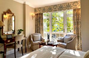 圣赫利尔泽西郎格维利庄园酒店的一间卧室配有一张床、一张书桌和一个窗户。