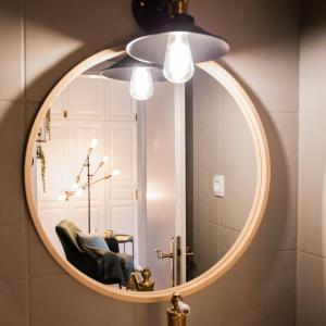 奥滕斯海姆Privatzimmer - Sieben an der Donau的浴室内的镜子,配有椅子和灯