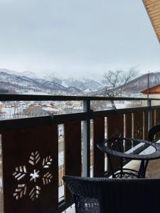 巴库里阿尼Villa B Barleon-Bakuriani的阳台配有桌子,享有雪覆盖的山脉美景