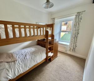 特里迪格Attenborough Cottage - 2 Bedroom Cottage的一间卧室设有两张双层床和一扇窗户。