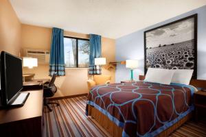 匹兹堡匹兹堡KS速8酒店的酒店客房配有一张床、一张书桌和一台电视。