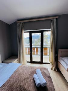 巴库里阿尼Villa B Barleon-Bakuriani的一间卧室设有一张床和一个大窗户