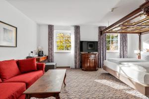 慕尼黑市中心国王高级酒店的酒店客房,配有一张床和一张红色的沙发