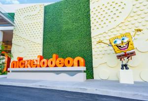 莫雷洛斯港Nickelodeon Hotels & Resorts Riviera Maya - Gourmet All Inclusive by Karisma的一张列子卡通人物站在建筑物旁边的标志旁
