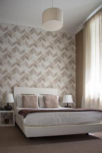 波尔图欧帕多赛文酒店的一间卧室配有一张床、两盏灯和一堵墙