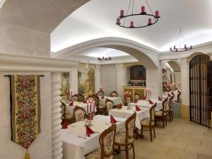 卡罗维发利Hotel Château Cihelny的一间配备有白色桌椅和吊灯的餐厅