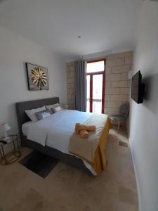 ŻabbarPalazzo Pisani Malta B&B的一间卧室设有一张大床和一个窗户。