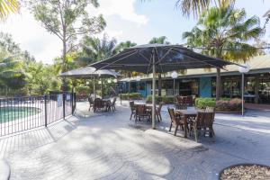 DurrasNRMA穆尔拉玛朗海滨度假酒店的一个带桌椅和遮阳伞的庭院