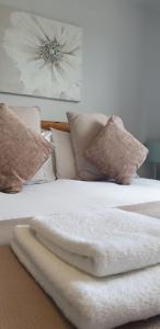 Dundonnell杜朵纳尔酒店的一张带白色毯子和枕头的床