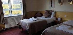 Dundonnell杜朵纳尔酒店的酒店客房设有两张床和窗户。